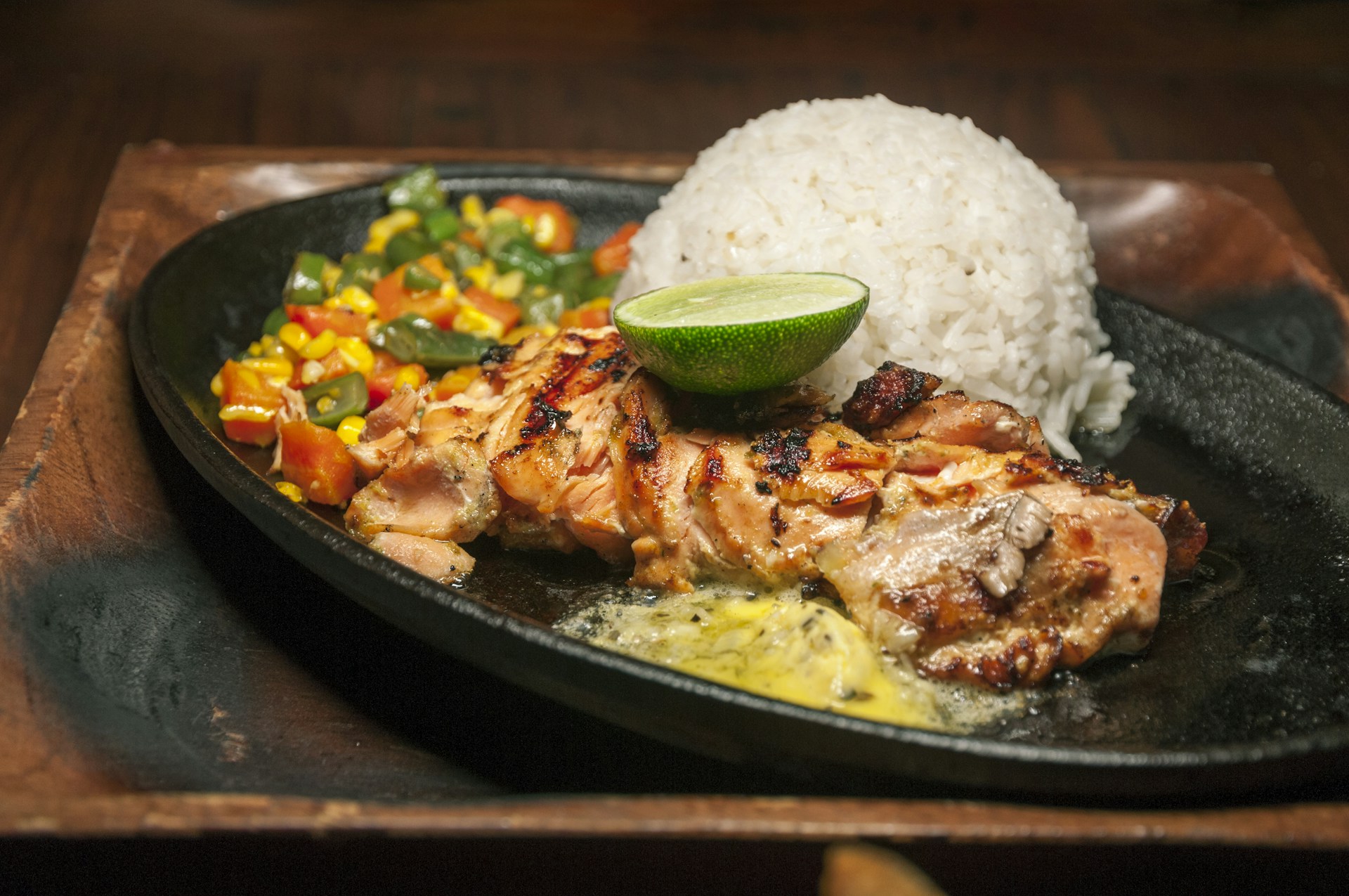 a plate of food with chicken, rice, and a lime