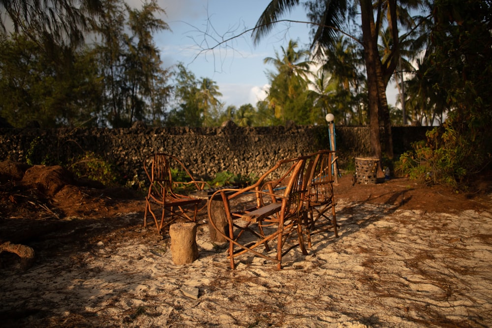 a wooden chair sitting on top of a dirt field