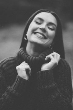 a black and white photo of a woman smiling