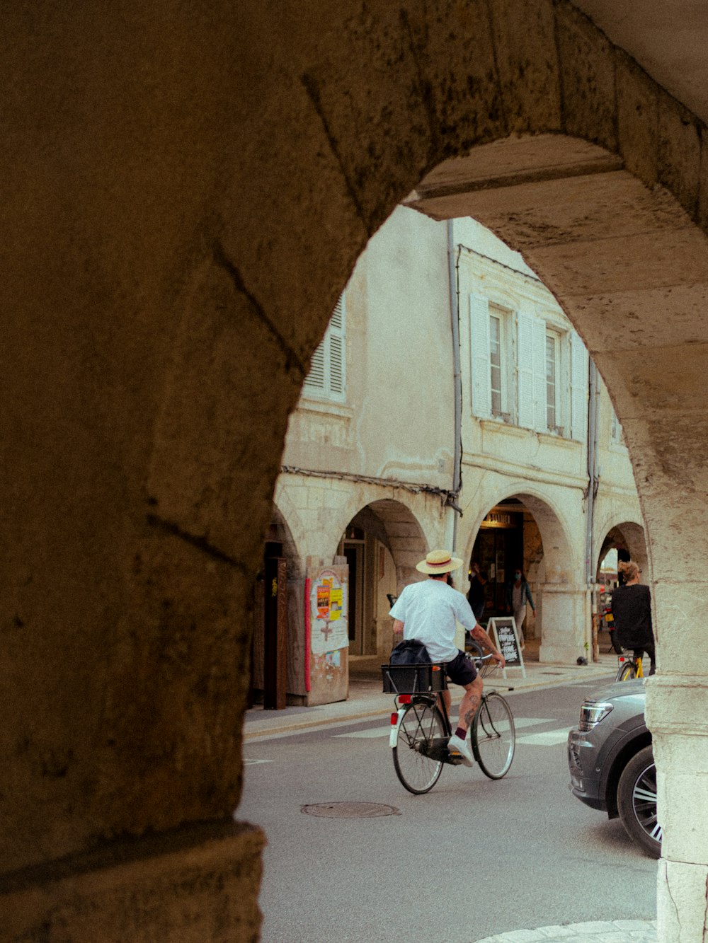 Un uomo che guida una bicicletta lungo una strada accanto a una macchina