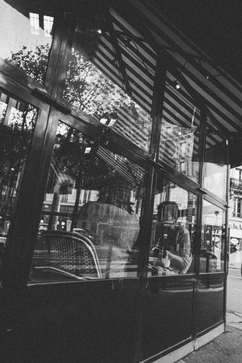 a black and white photo of a man sitting in a window