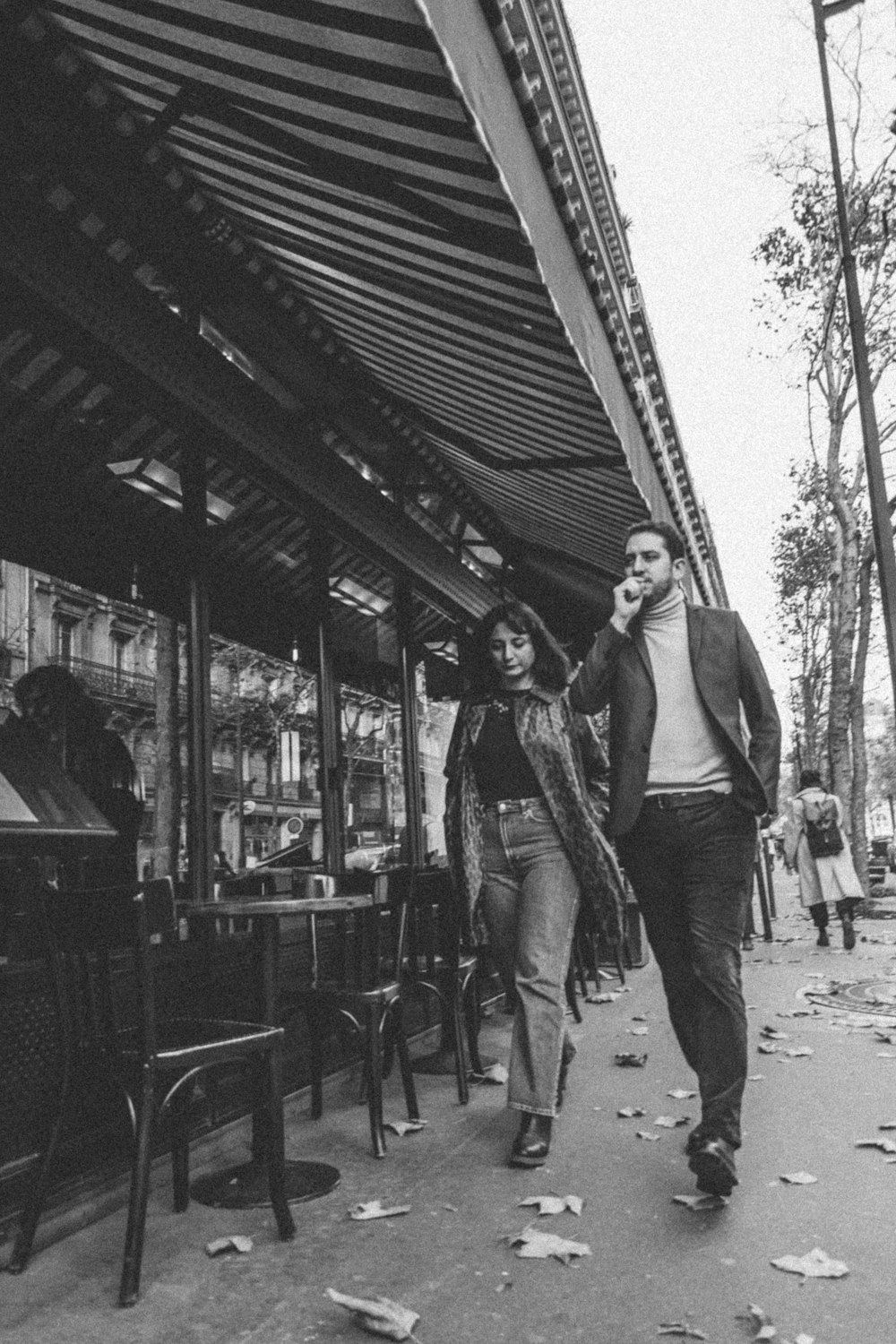 a man and a woman walking down a sidewalk