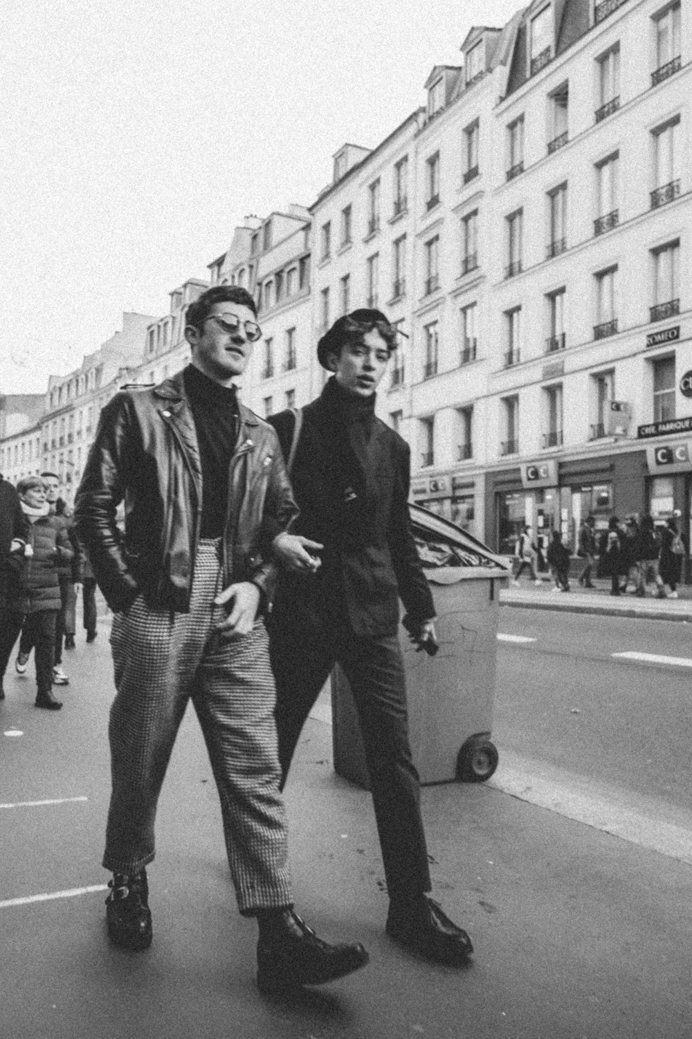 a couple of men standing next to each other on a street