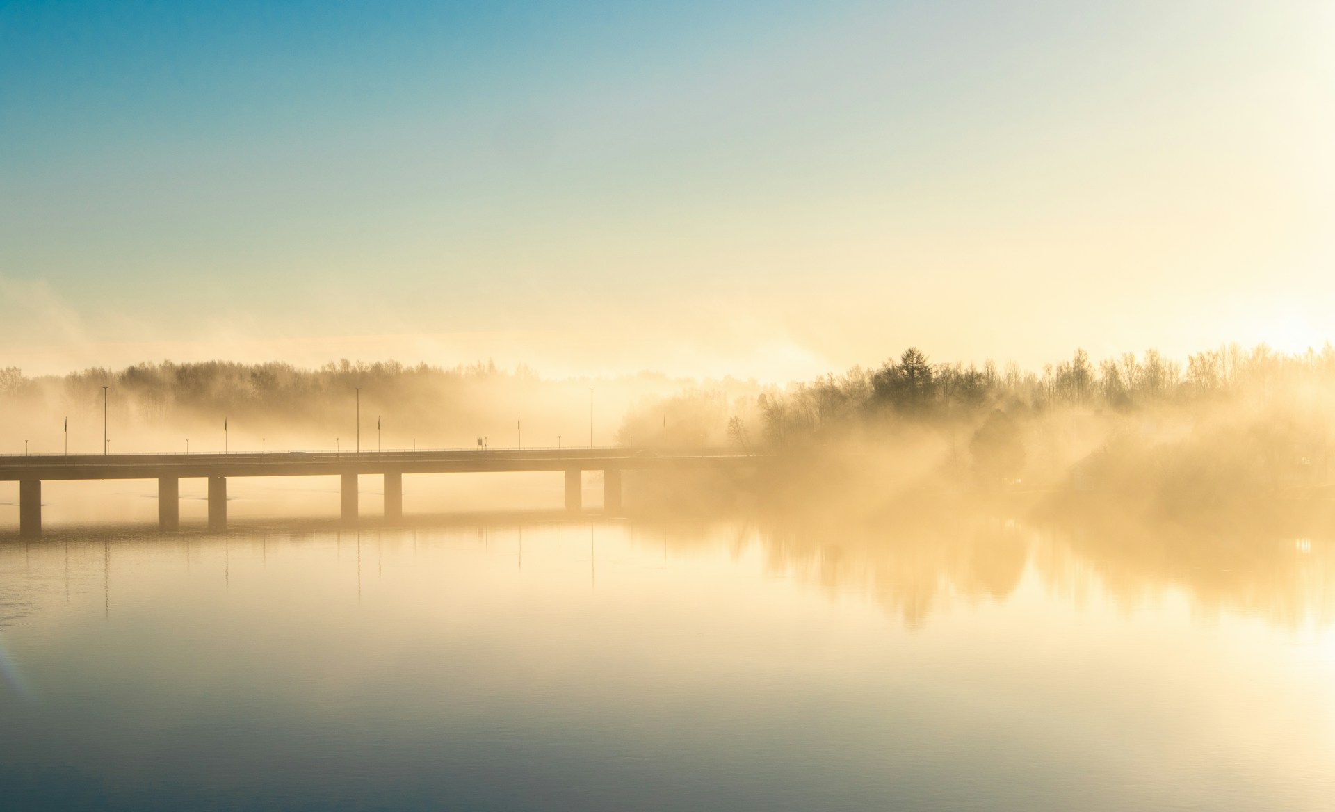 a bridge over a body of water on a foggy day