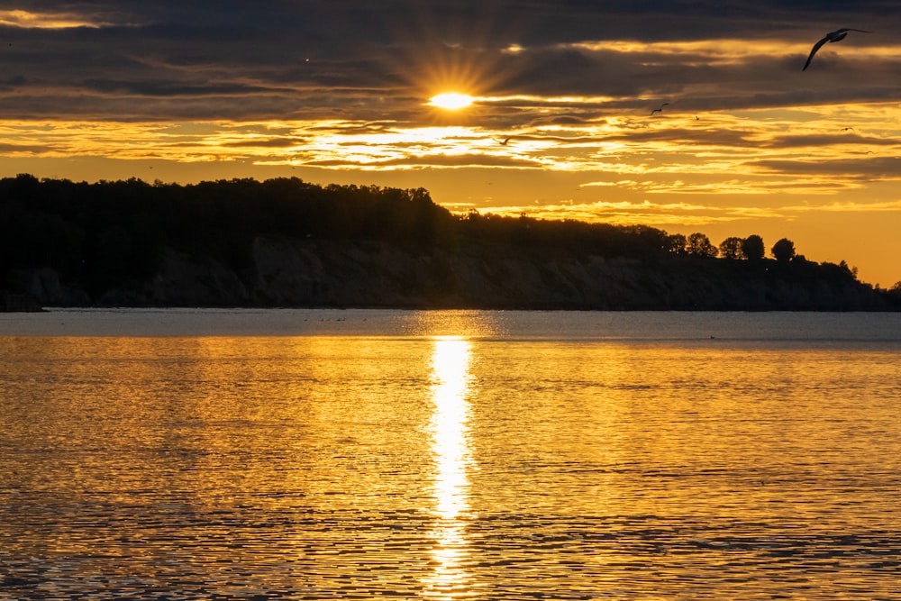 the sun is setting over a body of water