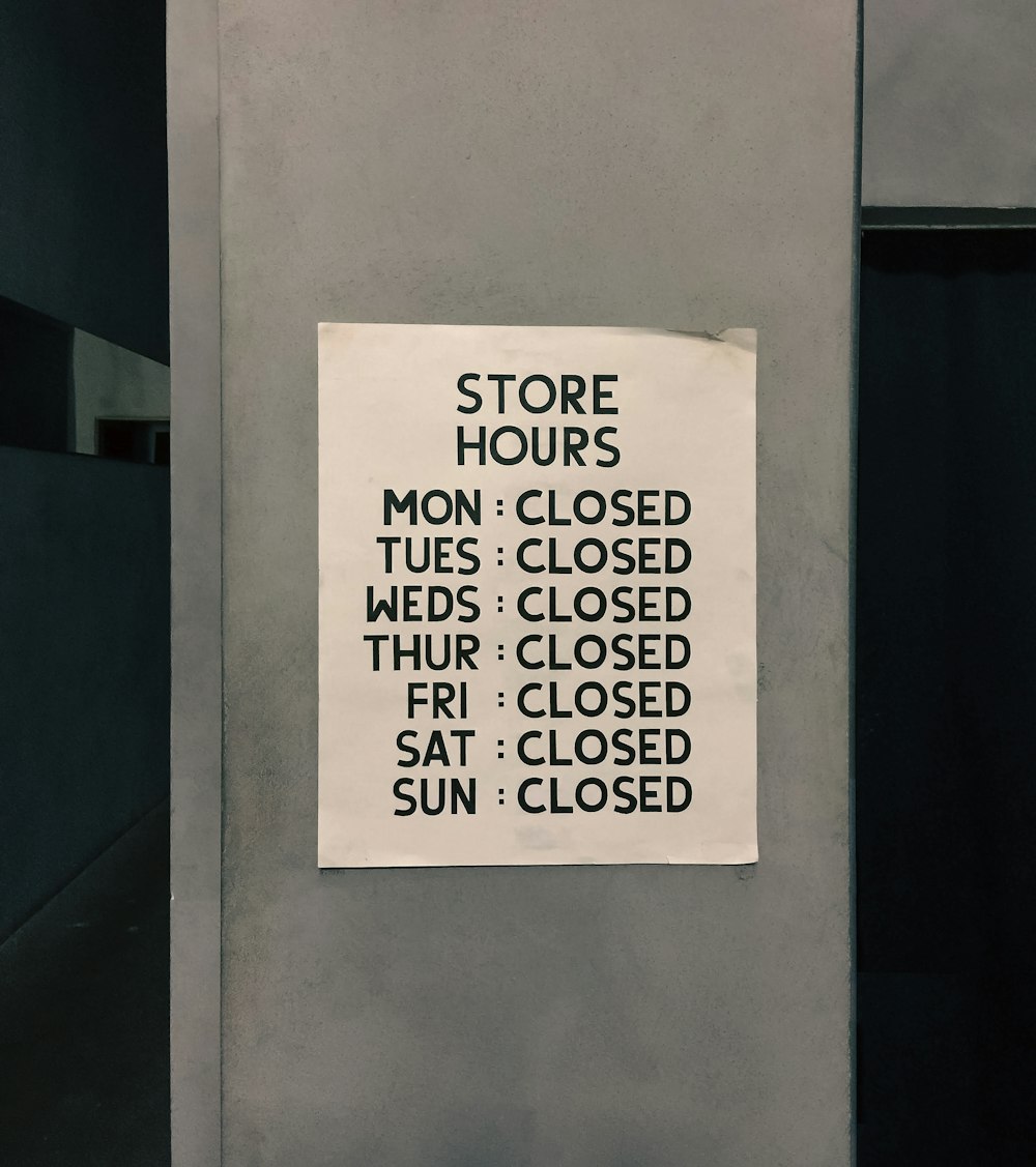 a store hours sign posted on a wall