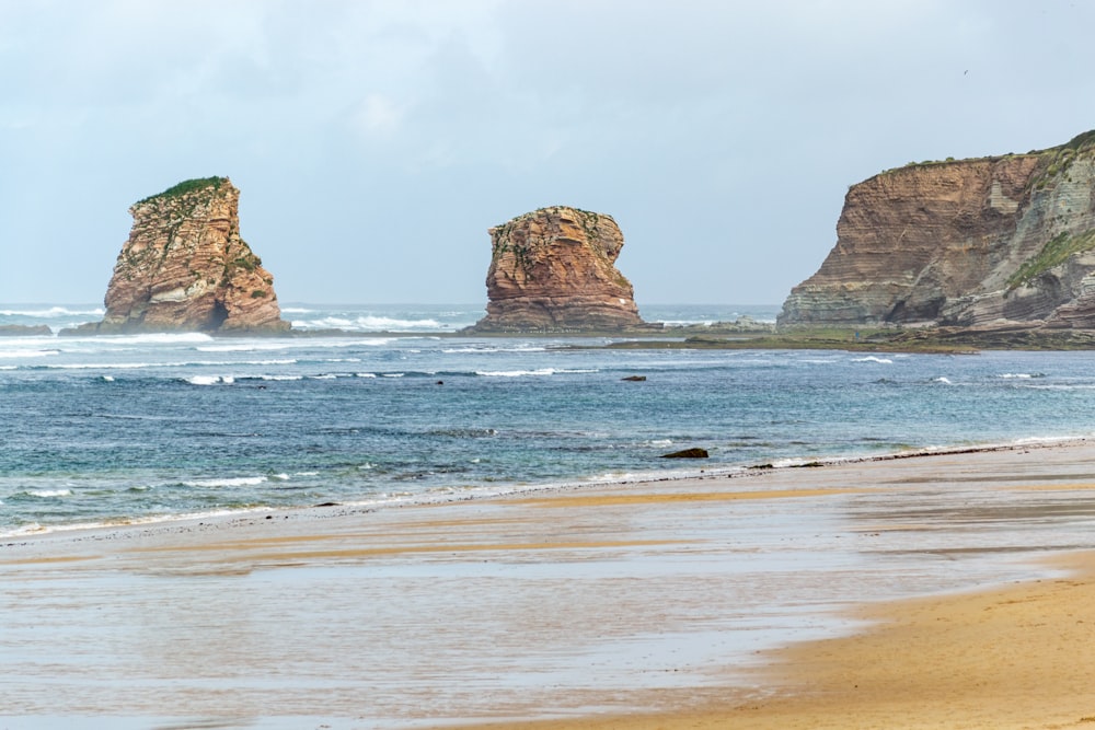 a couple of large rocks sitting on top of a beach