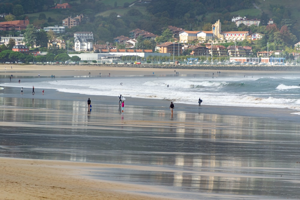 a group of people standing on top of a sandy beach