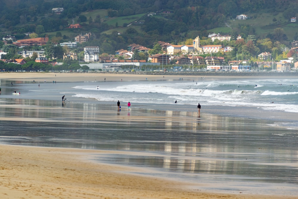 a group of people standing on top of a sandy beach