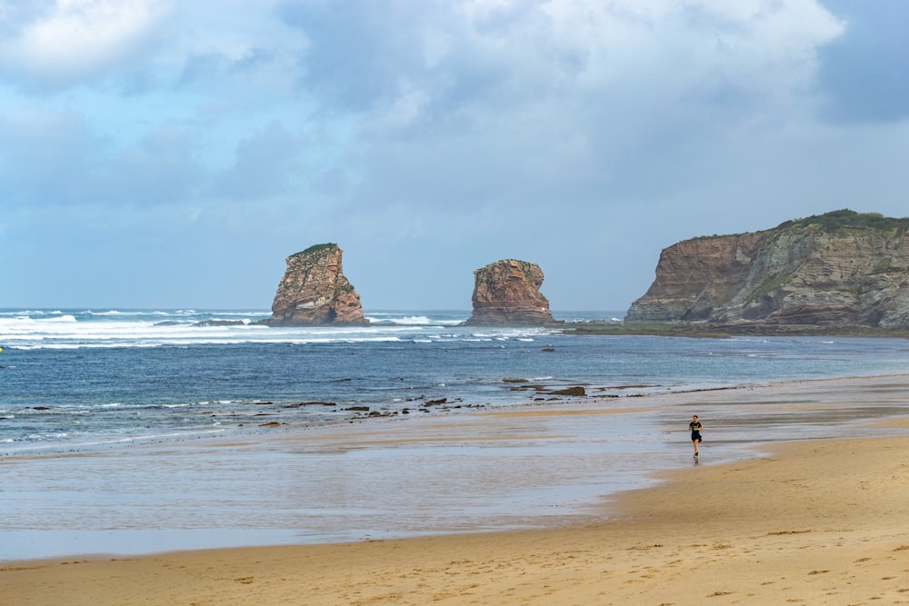 a person standing on a beach next to the ocean