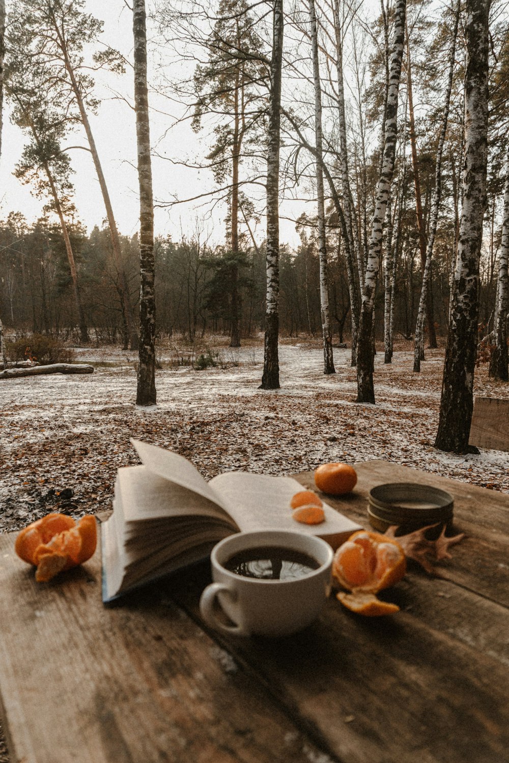 um livro aberto e uma xícara de café em uma mesa de madeira