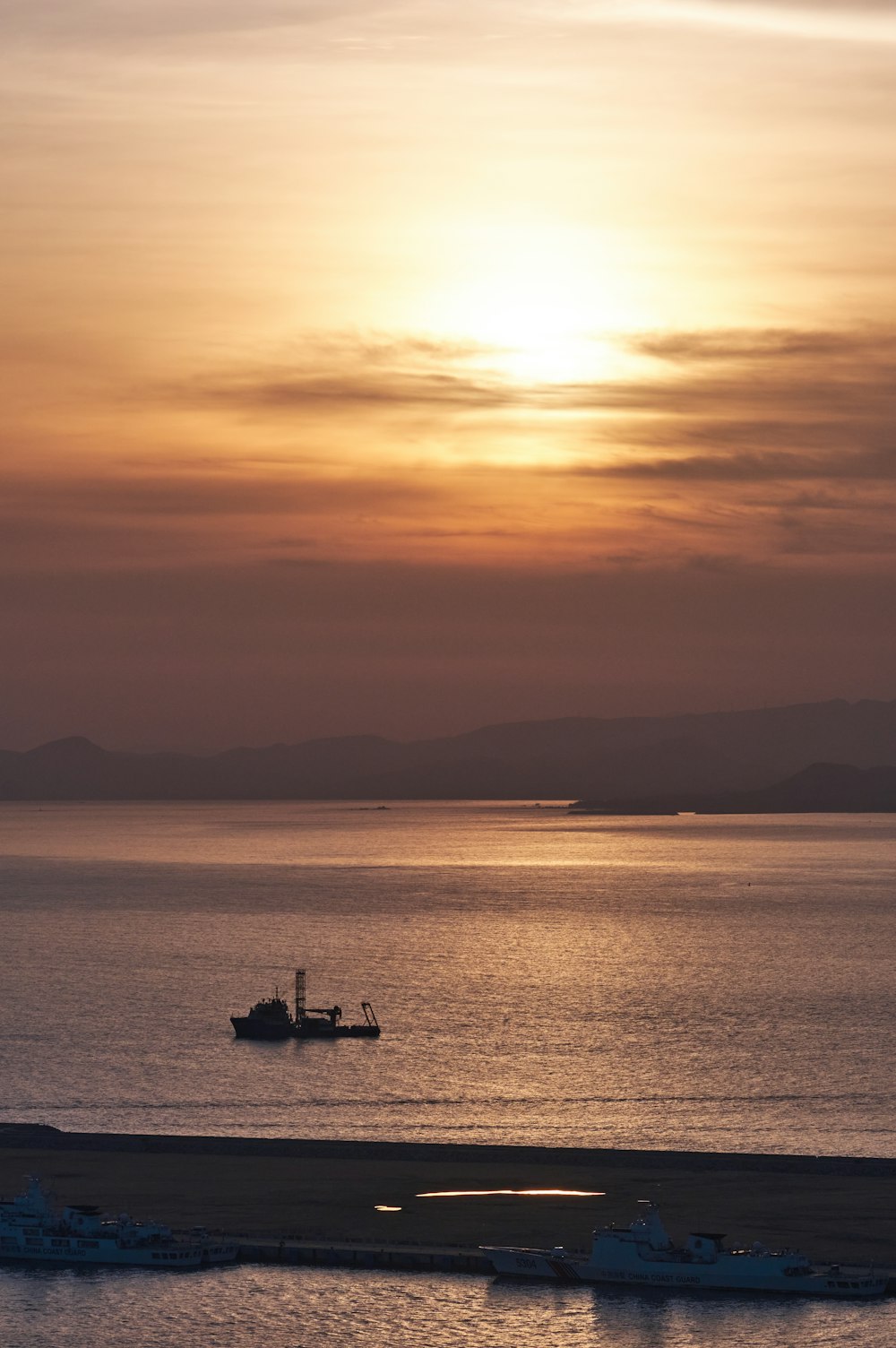 a boat is out on the water at sunset