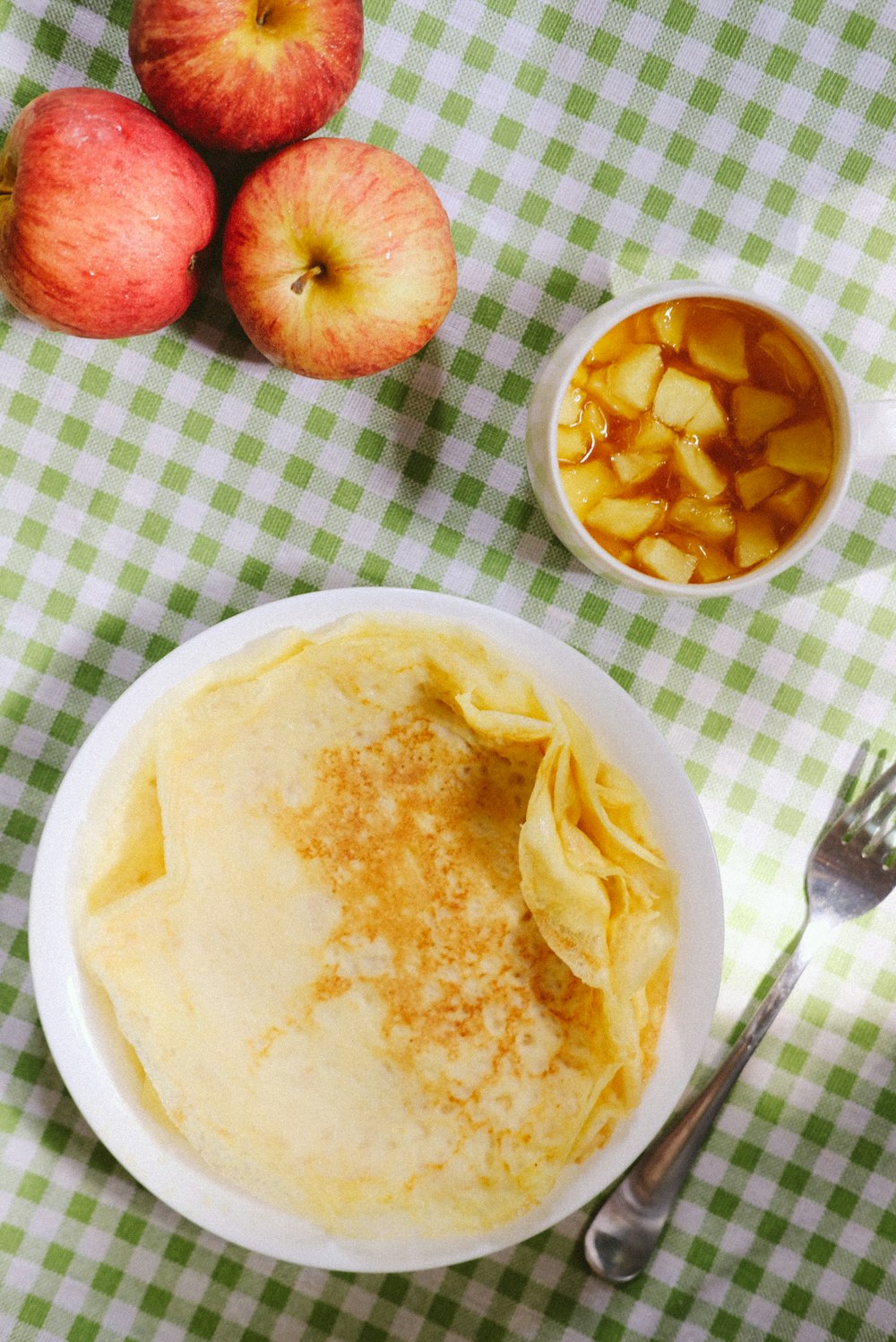 a plate of pancakes and apples on a table