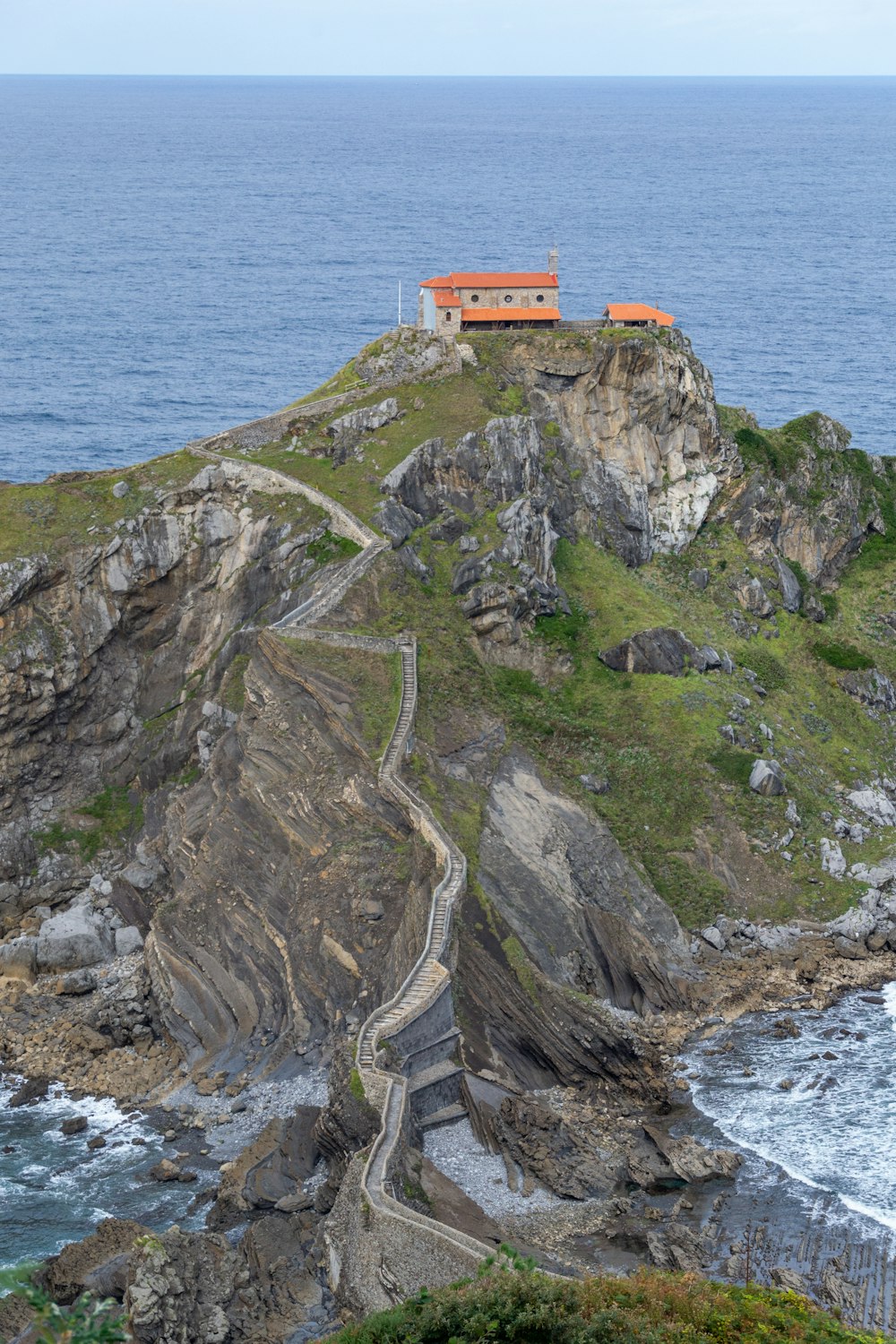 Una casa sentada en la cima de un acantilado junto al océano