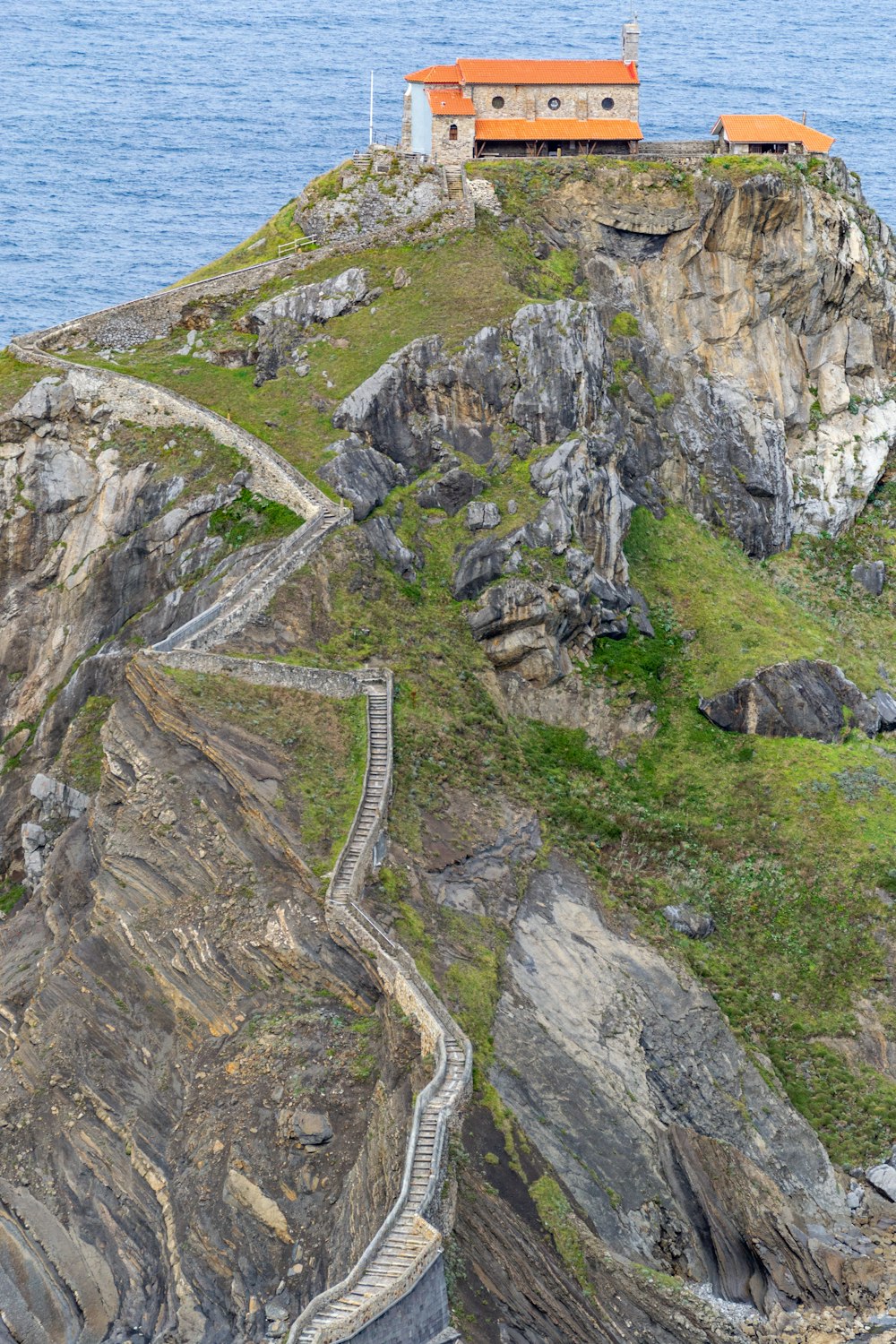 a lighthouse on a rocky cliff overlooking the ocean