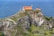 a house sitting on top of a cliff next to the ocean