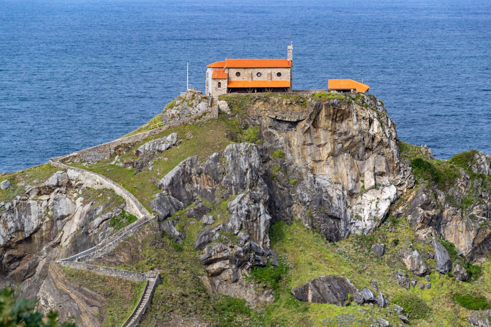 a house sitting on top of a cliff next to the ocean