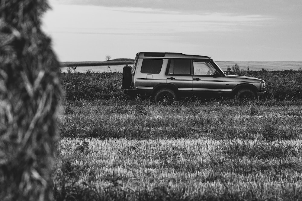 a black and white photo of a car in a field