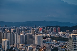 a large city with tall buildings and mountains in the background