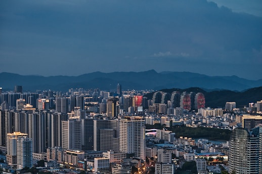 a large city with tall buildings and mountains in the background