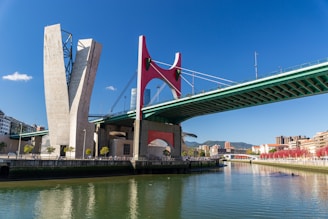 a bridge spanning over a river with a tall tower