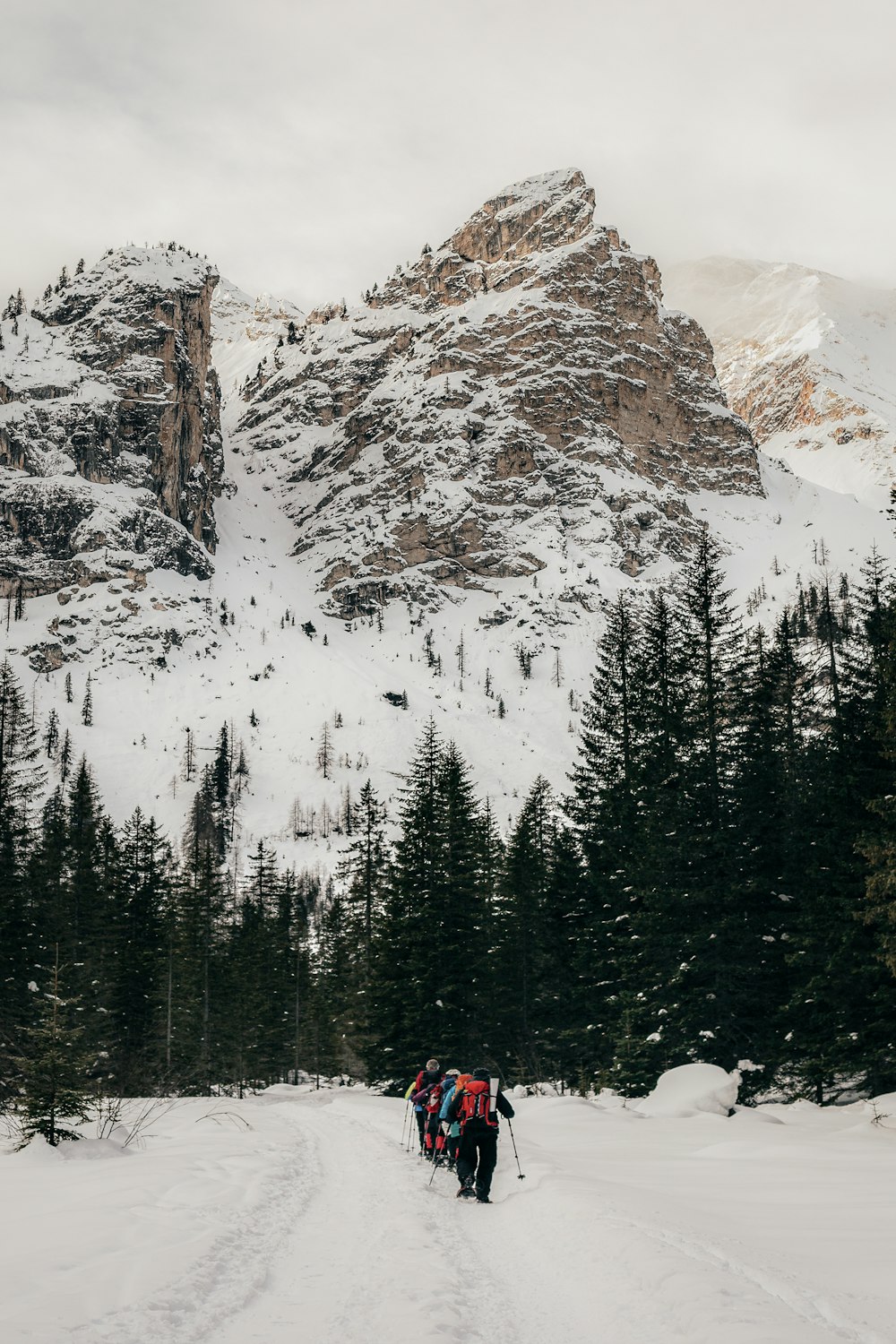 a couple of people walking across a snow covered field