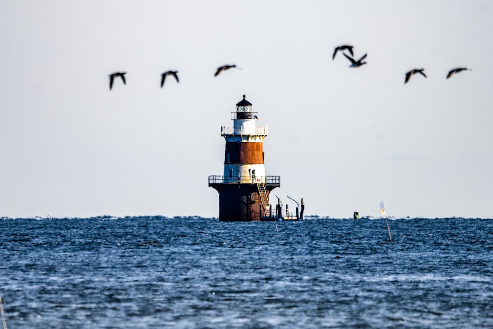 a large light house sitting on top of a body of water