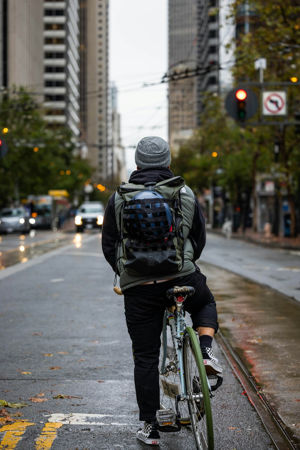 a man riding a bike down a street next to tall buildings