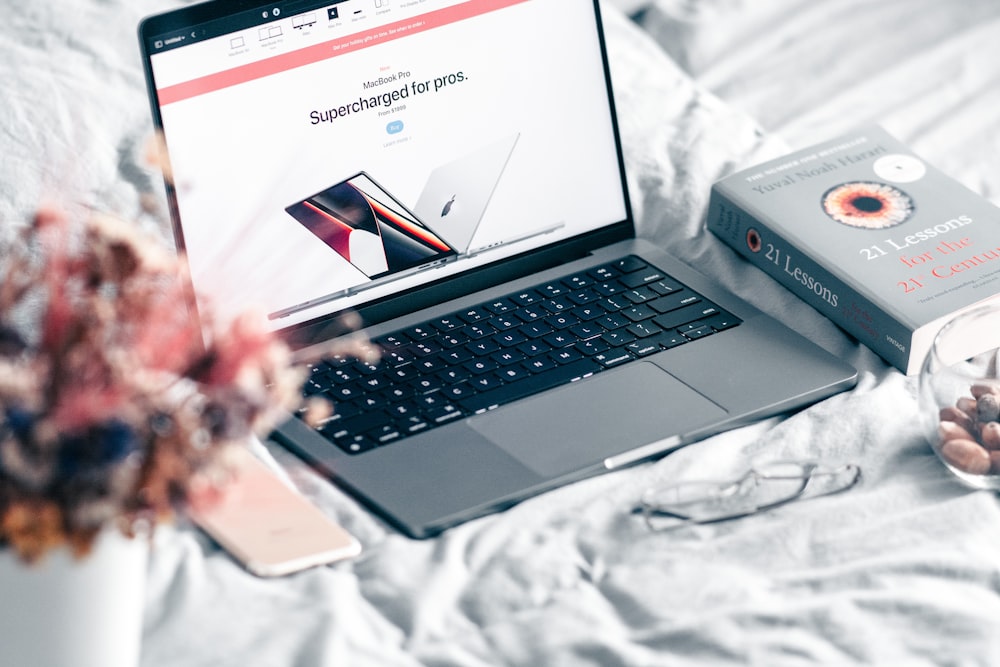 an open laptop computer sitting on top of a bed