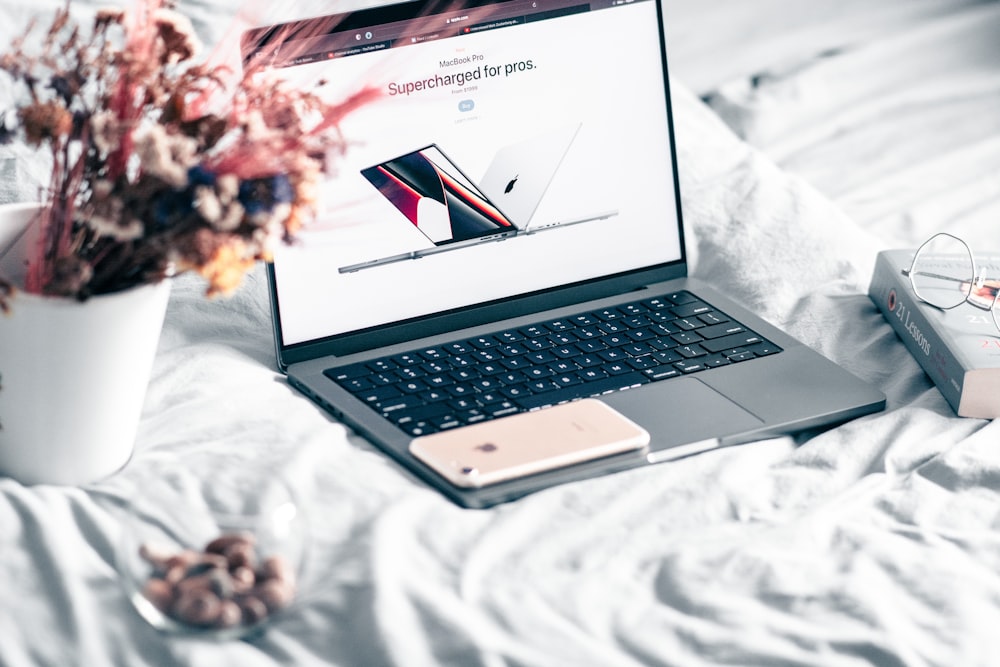 an open laptop computer sitting on top of a bed