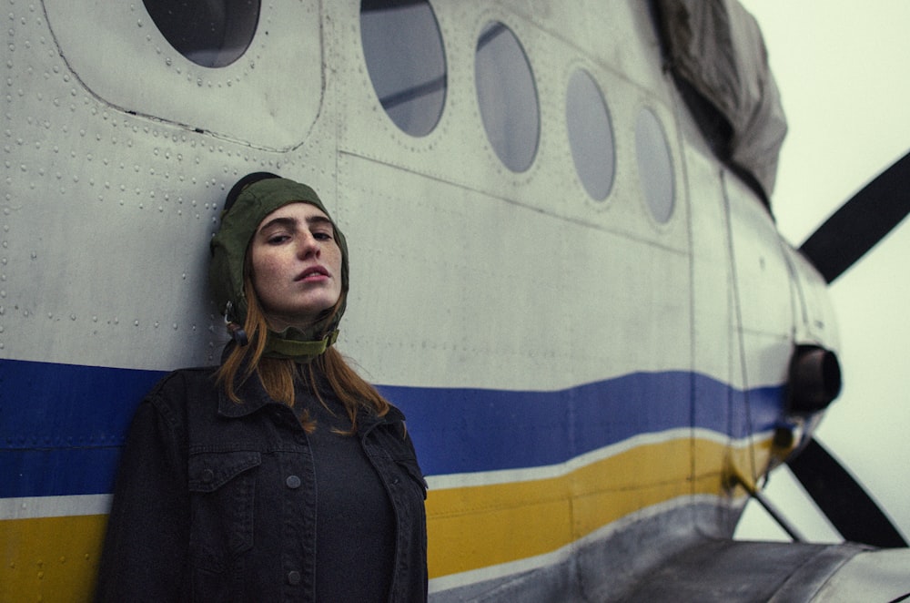 a woman leaning against the side of an airplane