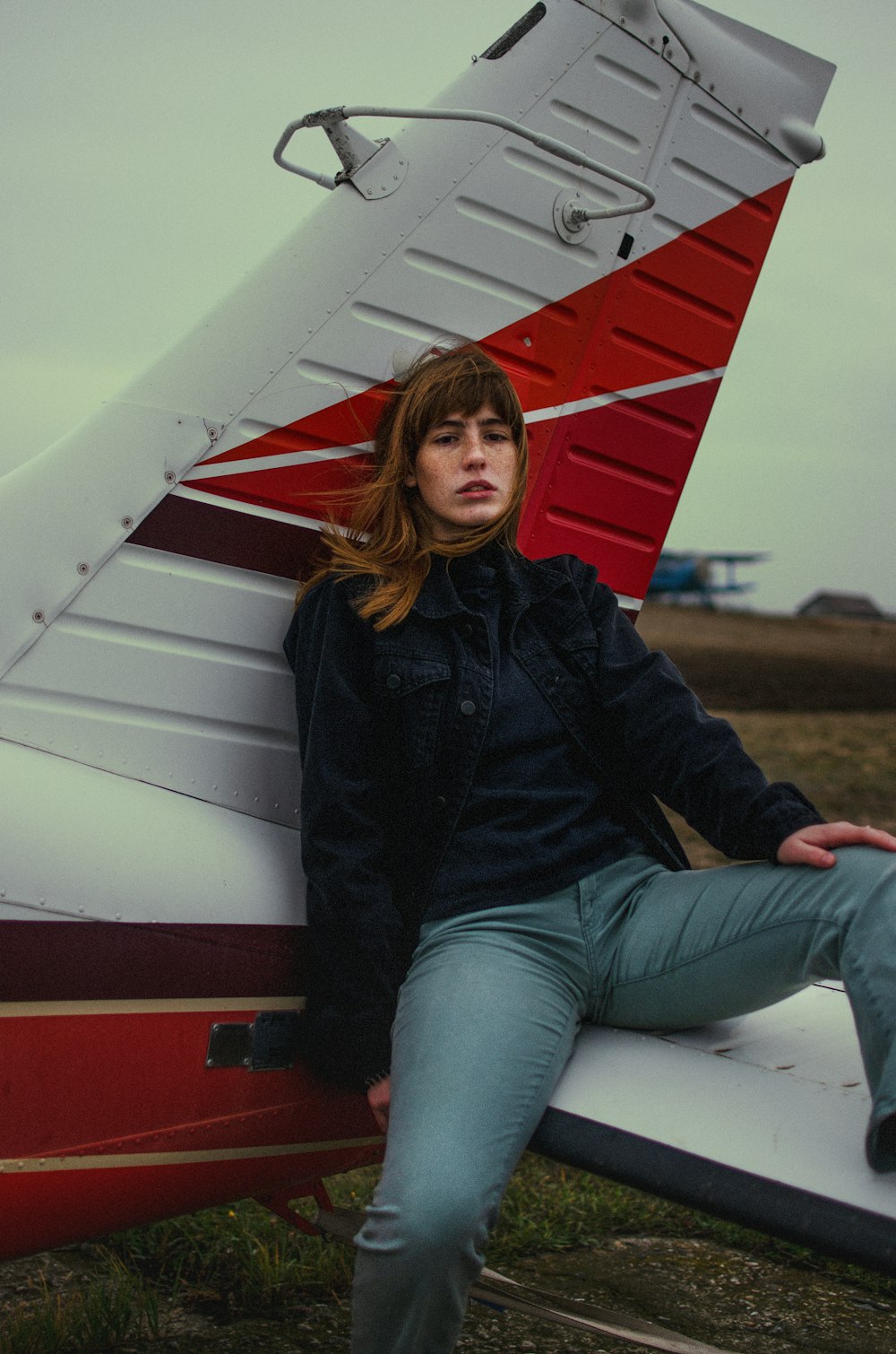 a woman sitting on the wing of a plane