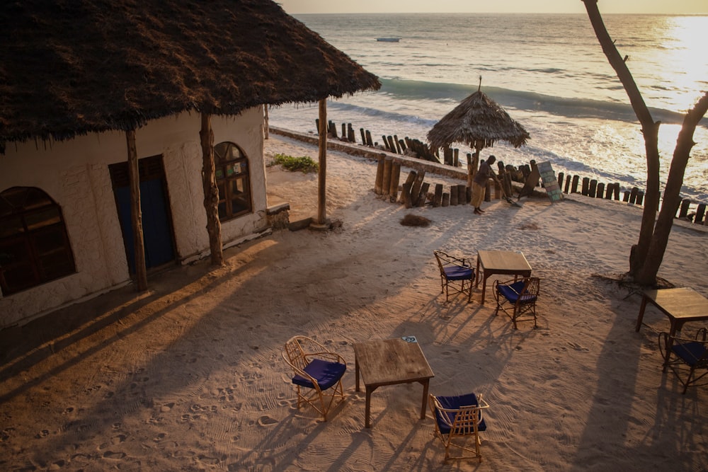 a group of chairs sitting on top of a sandy beach