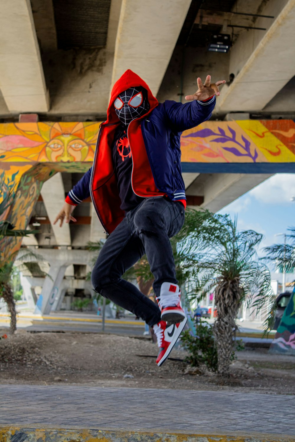 um homem em uma jaqueta vermelha e azul está fazendo um truque em um skate