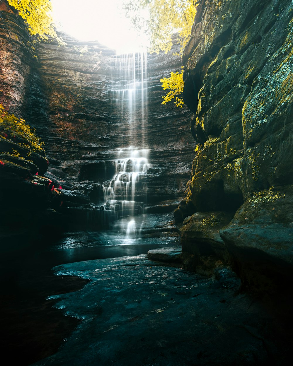 a waterfall with a waterfall cascading down it's side