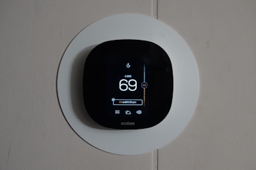 Close-up of a sleek smart thermostat displaying temperature settings.