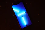 Modern smartphone displaying a vibrant interface surrounded by animated glowing particles and star-inspired motifs.