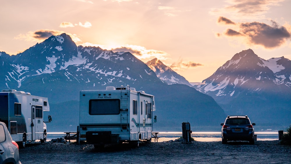 a couple of cars parked next to a couple of campers