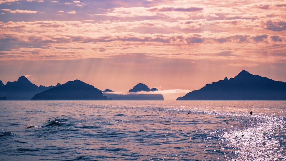 a body of water with mountains in the background