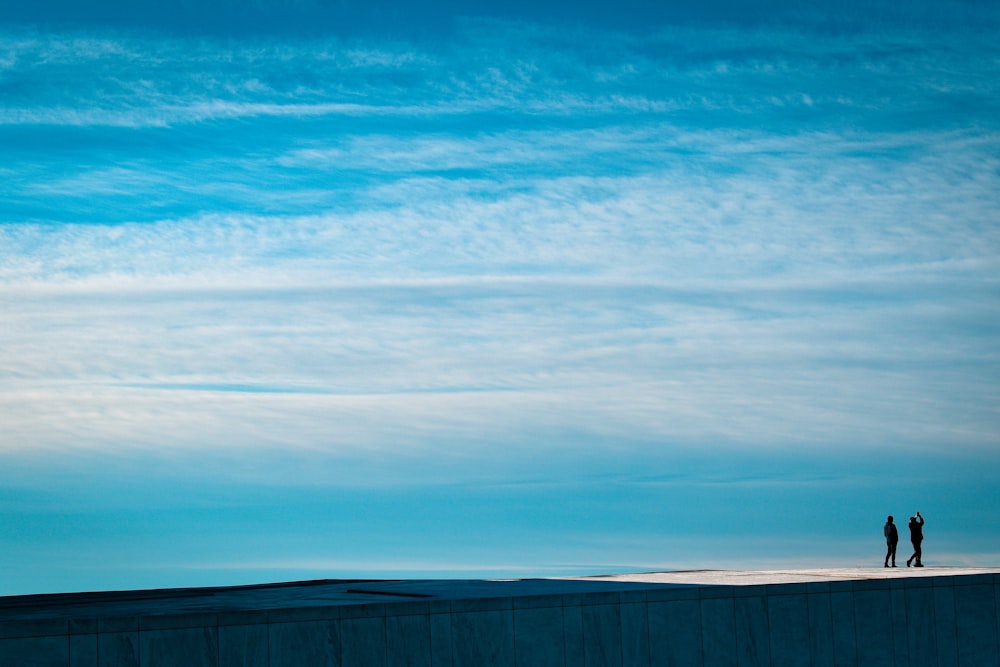 a couple of people standing on top of a roof