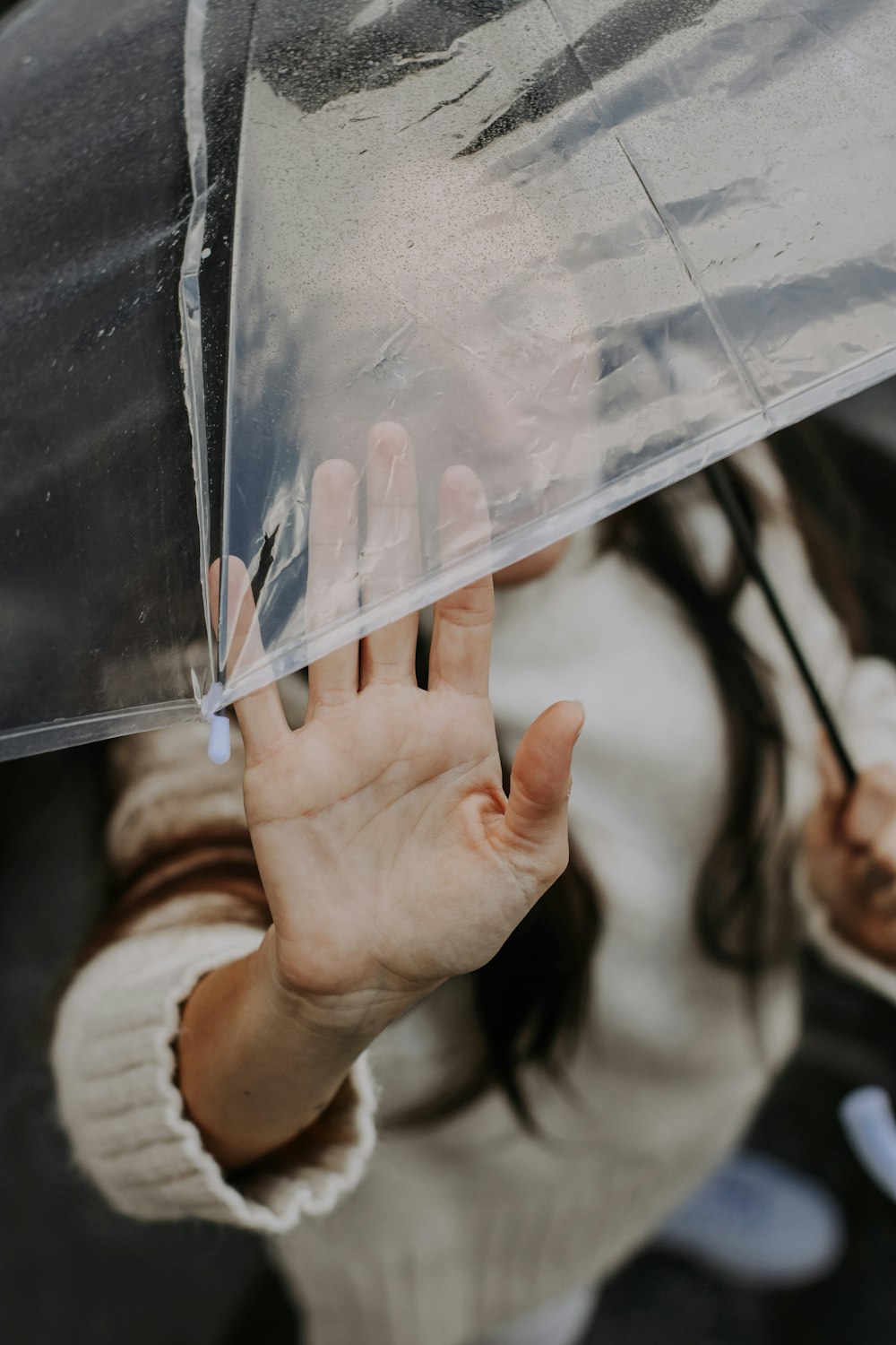 Une femme tenant un parapluie transparent au-dessus de sa tête