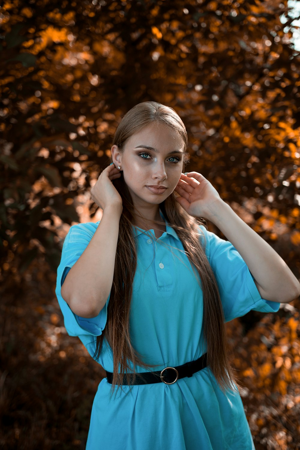 a girl in a blue dress posing for a picture