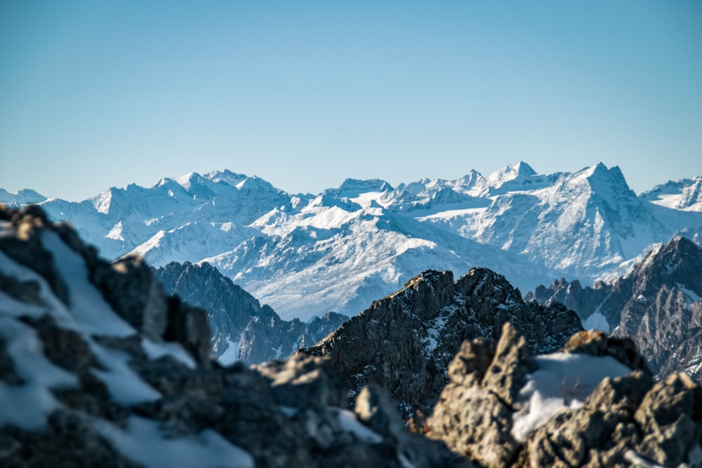 a mountain range covered in snow with mountains in the background
