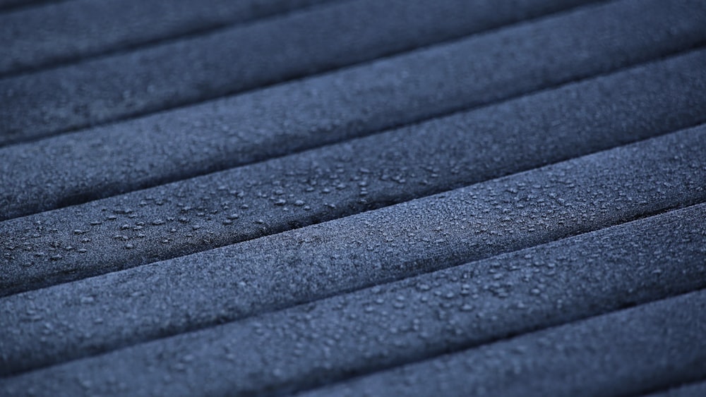 a close up of a black surface with water droplets