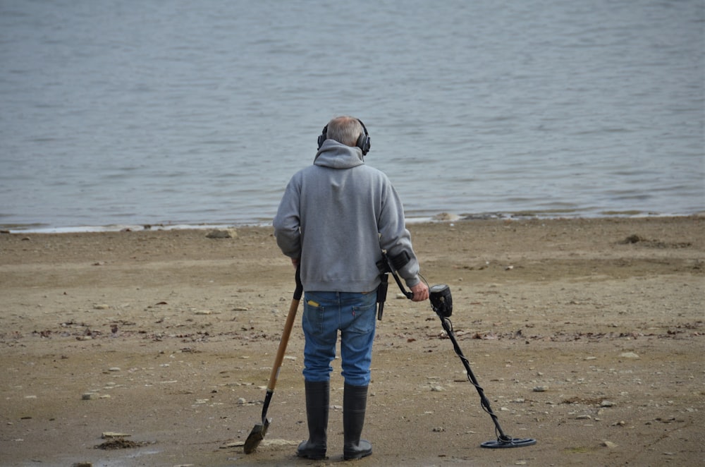 목발과 지팡이를 든 남자가 해변에 서 있다