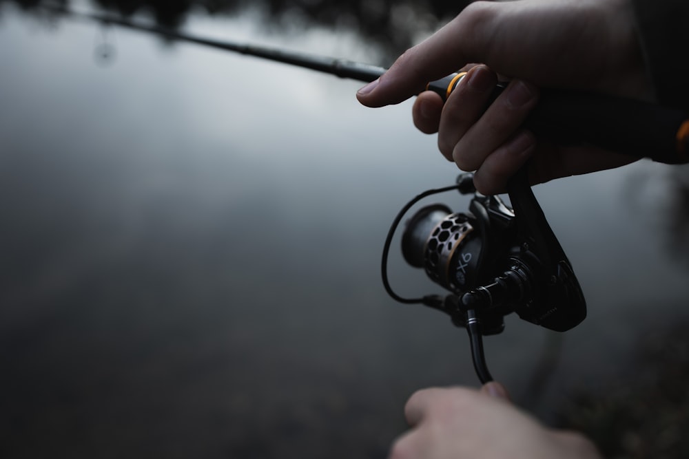 a person holding a fishing rod and spinning it