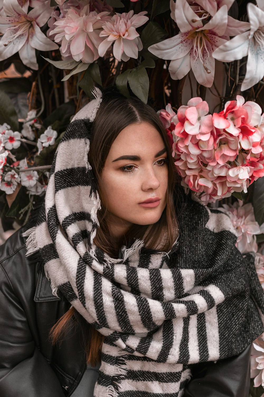 a woman wearing a black and white striped scarf