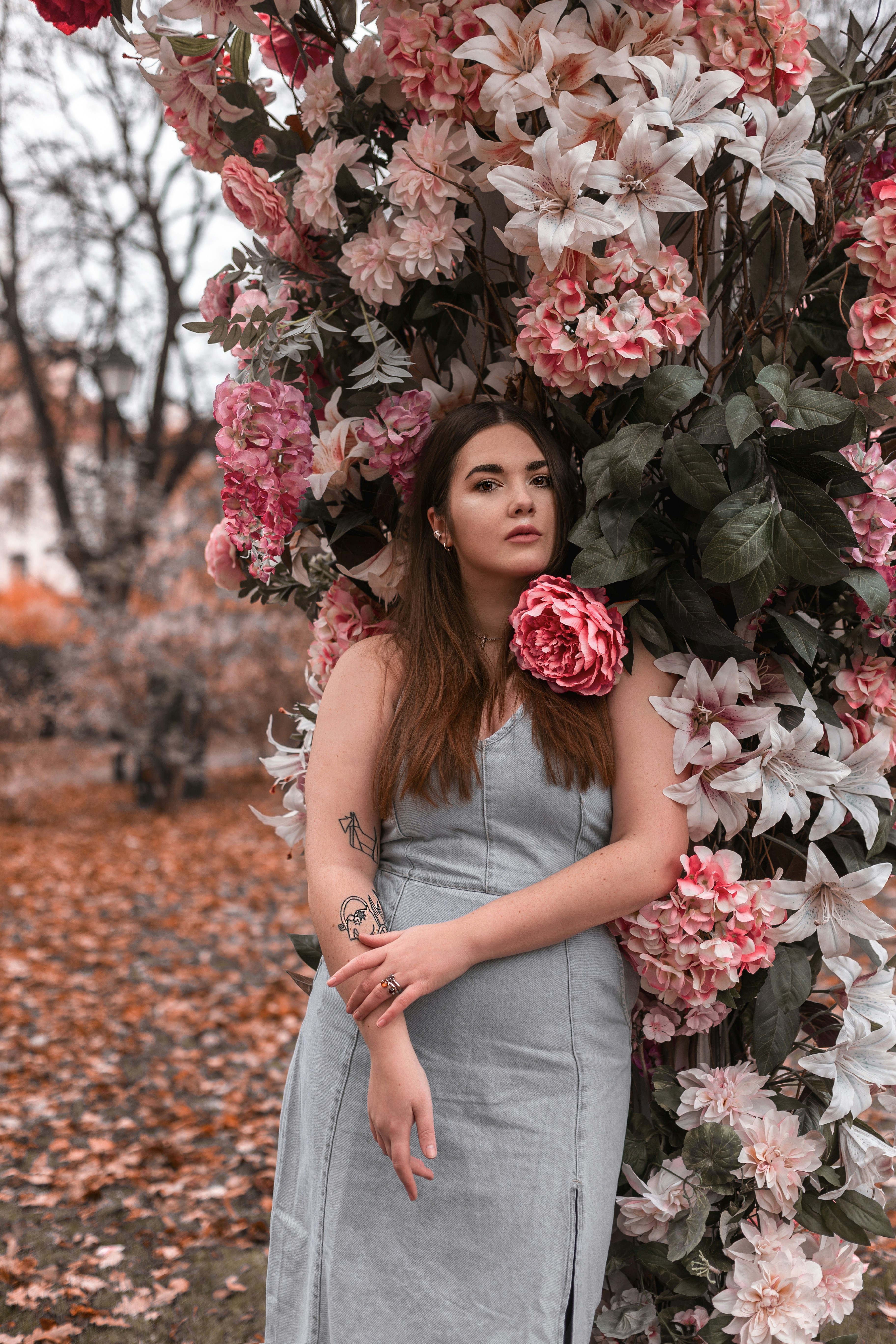 a woman standing under a flower covered tree