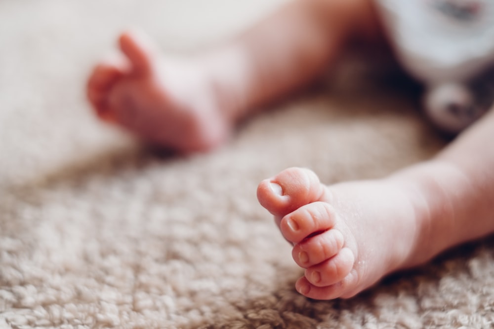 a close up of a baby's foot on a carpet