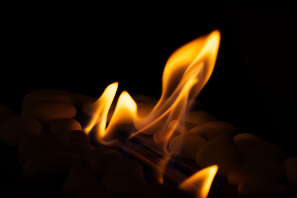 a close up of a fire with rocks in the background